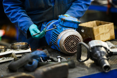 Person painting an electric motor blue